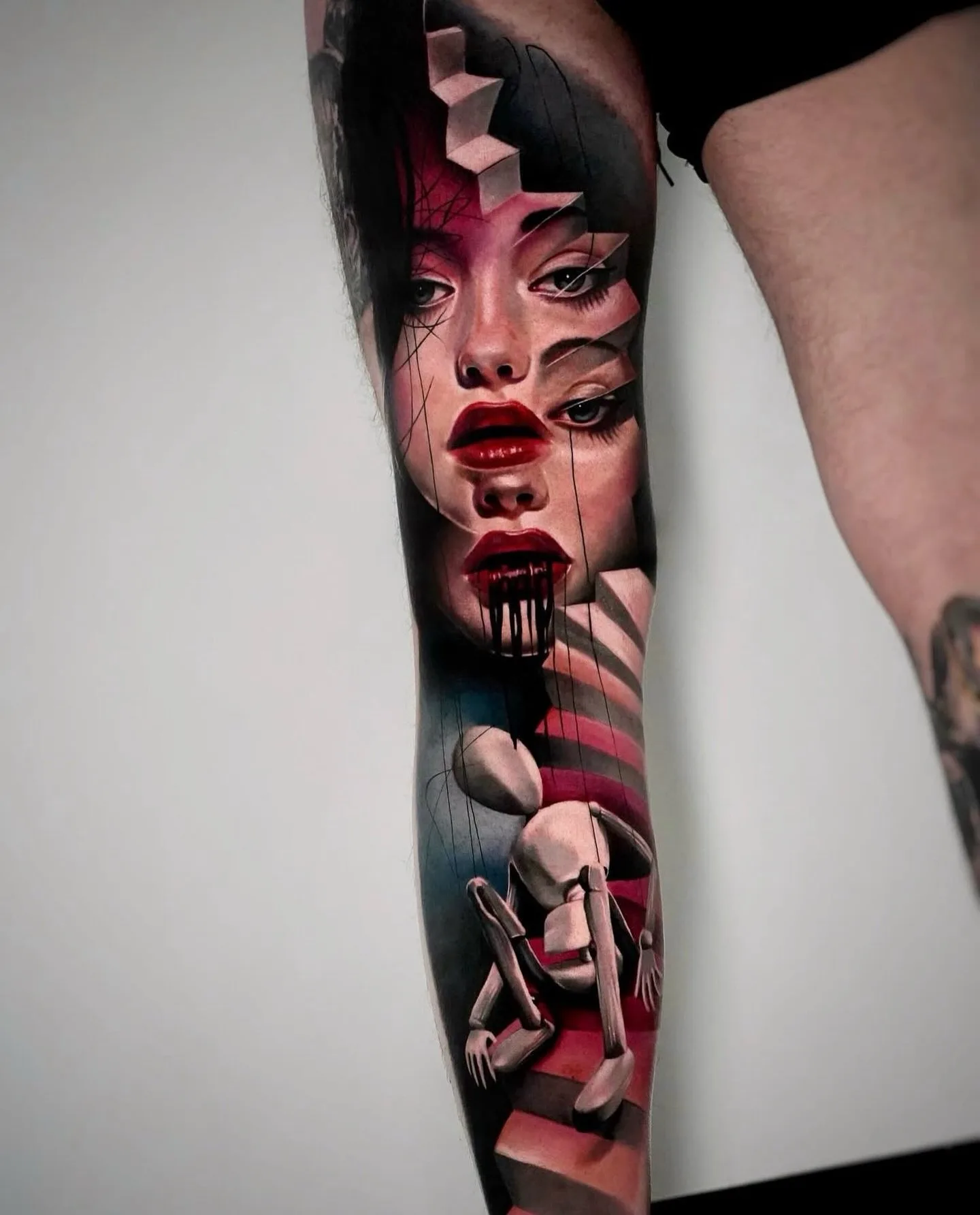 Realistisches Farbtattoo surreales Frauengesicht mit Holzpuppe am Bein – Prime Ink Bremen
