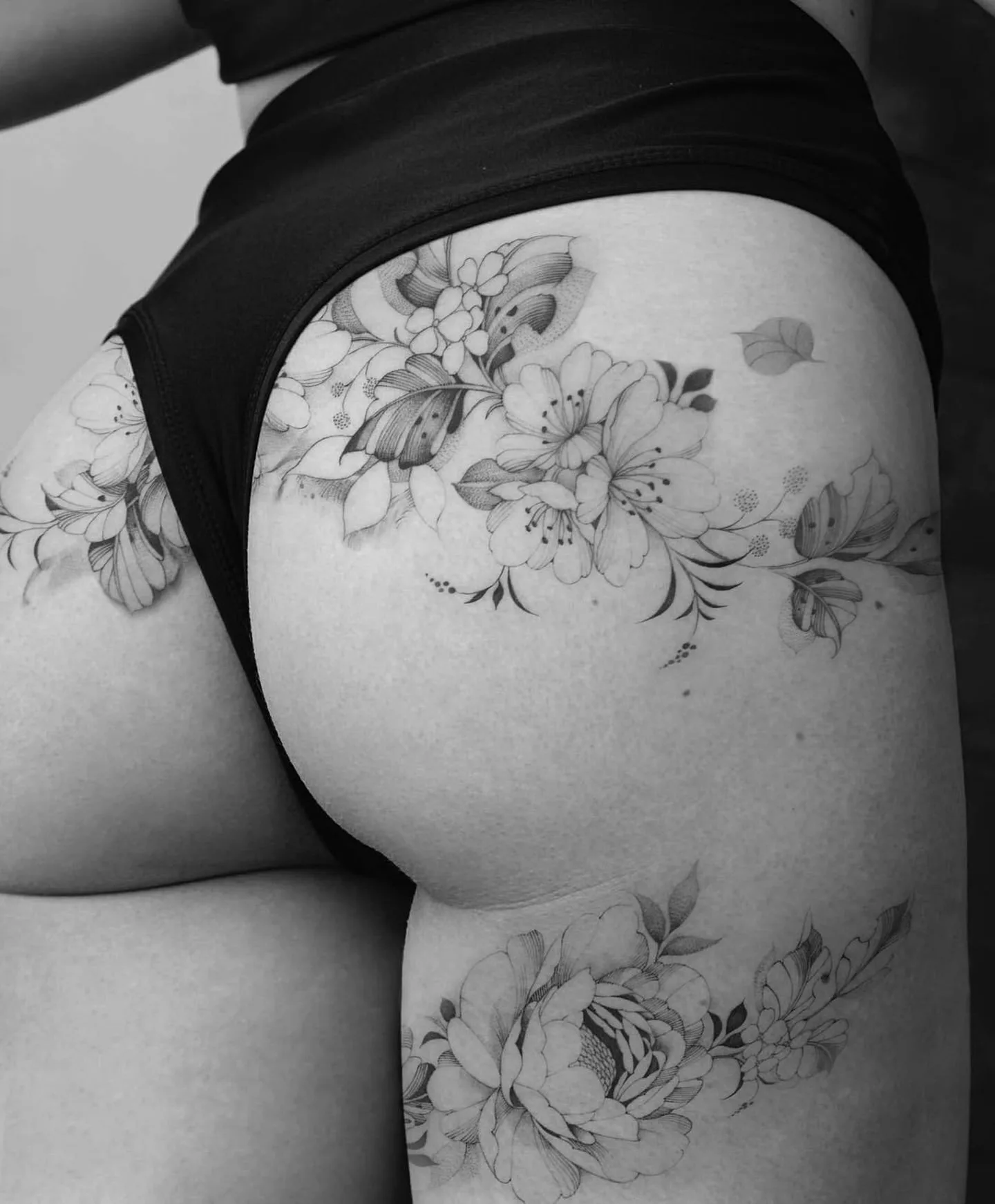 Fineline Tattoo Blumenranke an Hüfte und Oberschenkel – Prime Ink Bremen