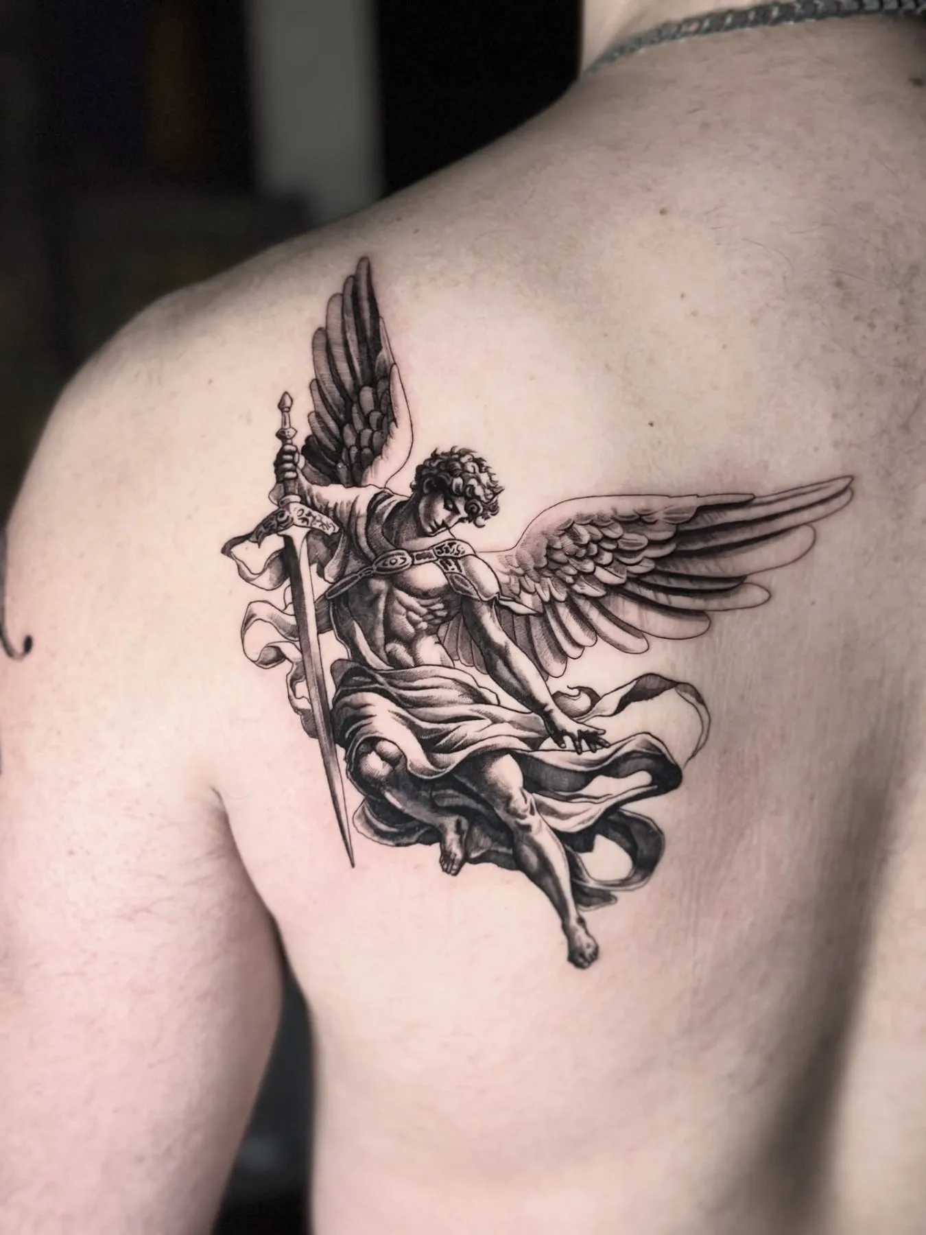 Fineline Tattoo Erzengel mit Schwert am Schulterblatt – Prime Ink Bremen