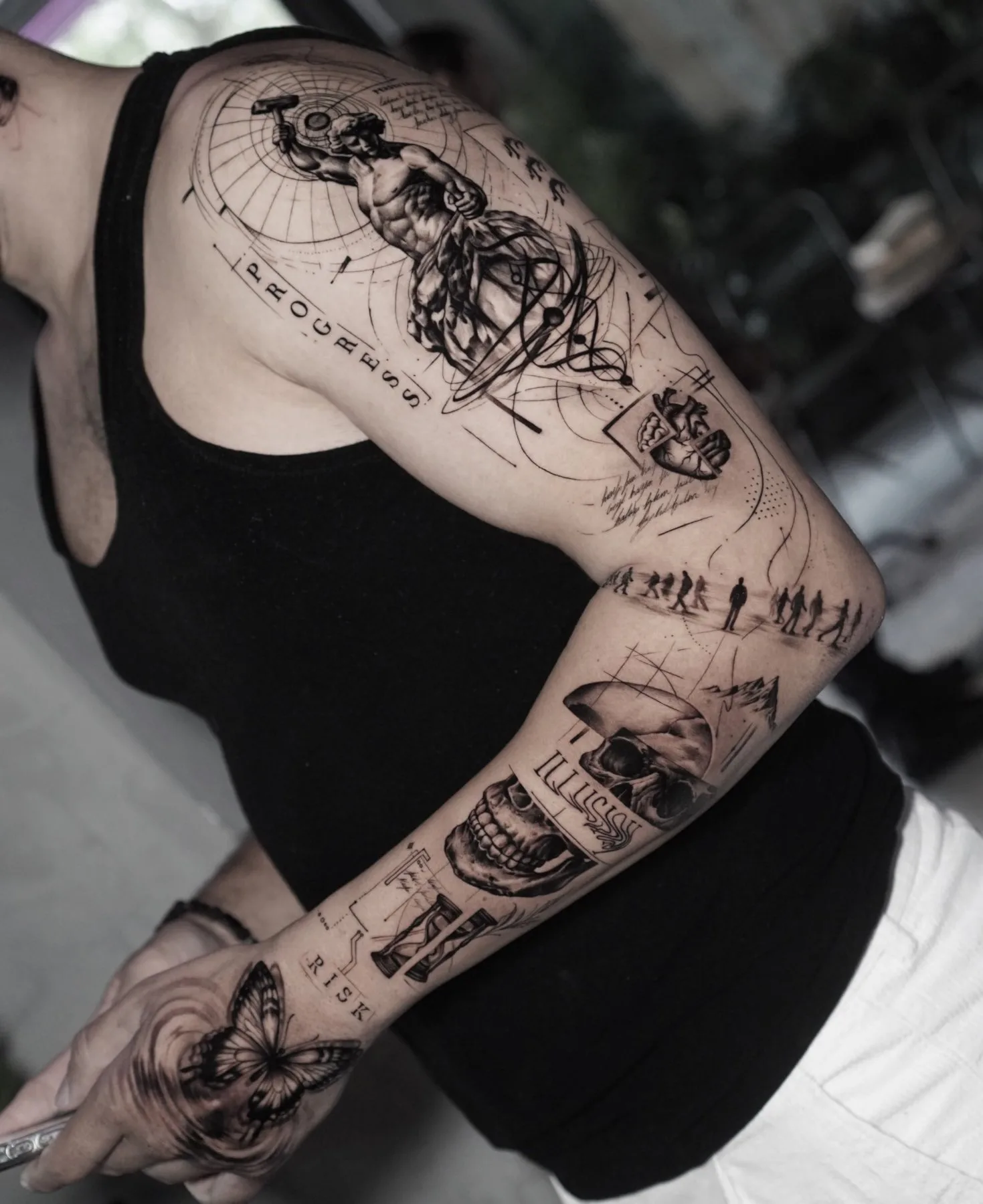 Fineline Sleeve mit Statue, Totenkopf und Schriftzügen am Arm – Prime Ink Bremen