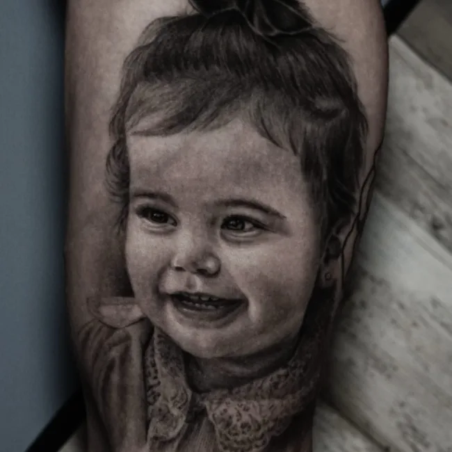 Realistic Black and Grey Kinderportrait Tattoo am Oberarm – Vroma, Prime Ink Bremen